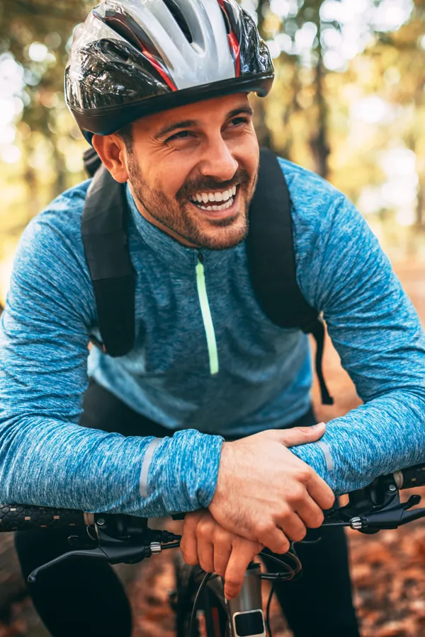A smiling man getting ready for a cycling trip. Get treatment for adrenal hormone disorder from Tanya Zboril, NP of TBT Medical in Edmonton.