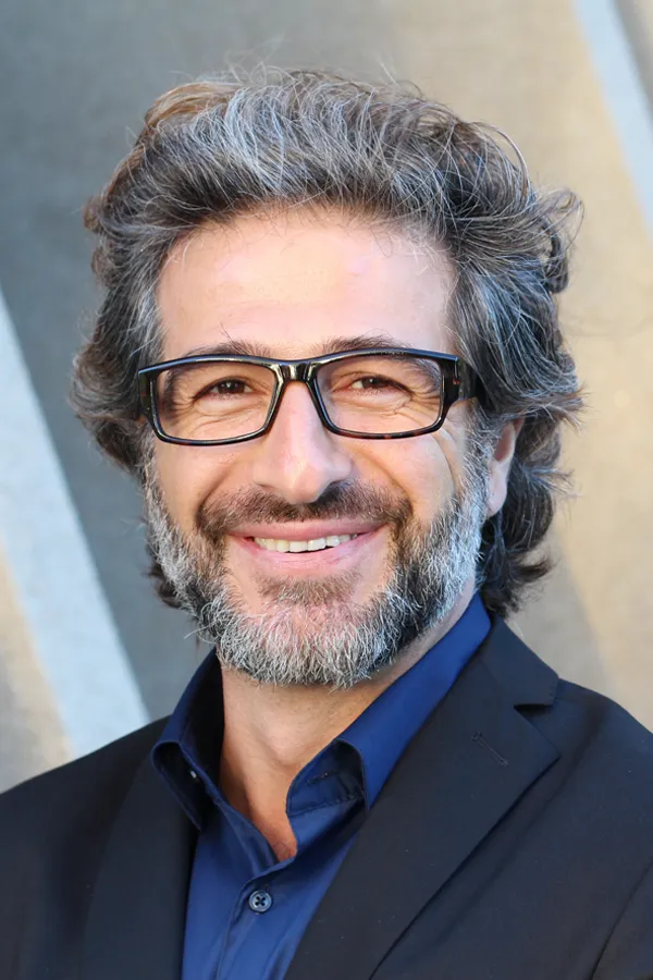 A man with glasses, salt and pepper hair and a beard smiling because he received treatment for andropause and low testosterone from Tanya Zboril, NP of TBT Medical in Edmonton.