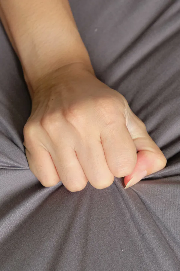 Close-up of a woman's hand grabbing a sheet, indicating sexual pleasure. Get female sexual dysfunction treatment from Tanya Zboril, NP of TBT Medical in Edmonton.