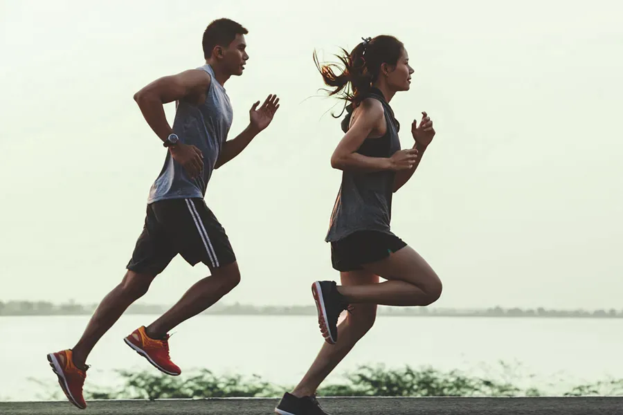 A couple in profile running along the water. Schedule GLP-1 Weight Loss Injections from Tanya Zboril, NP of TBT Medical in Edmonton.