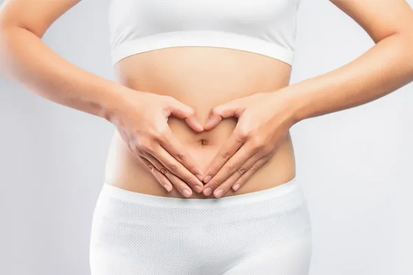 A woman holds her hands in a heart shape around her gut area. Schedule Targeted Gut Microbiome therapy from Tanya Zboril, NP of TBT Medical in Edmonton.