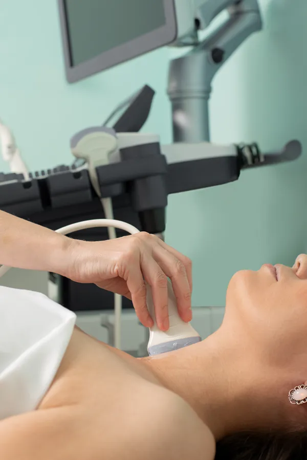 A woman gets a thyroid scan from a doctor in a clinic. Get help with Hashimoto's Thyroiditis from Tanya Zboril, NP of TBT Medical in Edmonton.