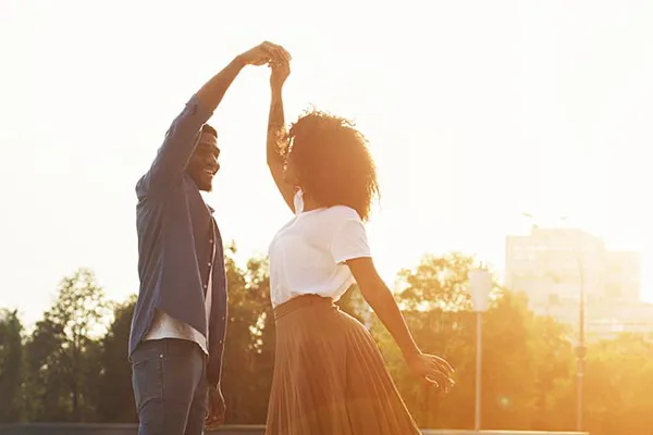 Immunotherapy-Doctor A black couple dances outside lit by the sunset. Get immunotherapy for autoimmune diseases from Tanya Zboril, NP of TBT Medical in Edmonton.