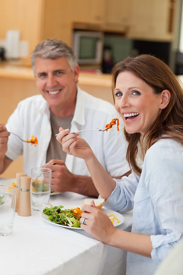 Improve digestion with Tanya Zboril, NP of TBT Medical's Functional Medicine for Leaky Gut Syndrome care in Edmonton, featuring a happy couple enjoying a nutritious lunch at home.