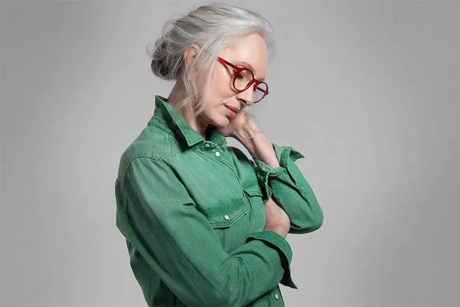 Low-Dose-Naltrexone-Clinic A middle-aged woman in a green shirt holds her neck and grimaces in pain. Schedule low dose naltrexone treatment from Tanya Zboril, NP of TBT Medical in Edmonton.