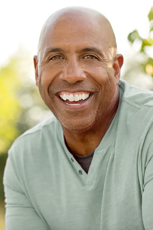 Low-Dose-Naltrexone-Treatment A man in a green shirt sits outside smiling and pain-free. Get low dose naltrexone treatment from Tanya Zboril, NP of TBT Medical in Edmonton.