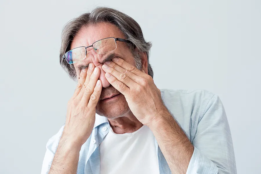 Get migraine relief with Tanya Zboril, NP of TBT Medical's functional medicine for migraines treatment in Edmonton, represented by an older man rubbing his eyes due to head pain.