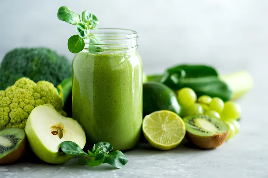 A tableau of healthy green fruits and vegetables and juices. Get nutritional counseling from Tanya Zboril, NP of TBT Medical in Edmonton.
