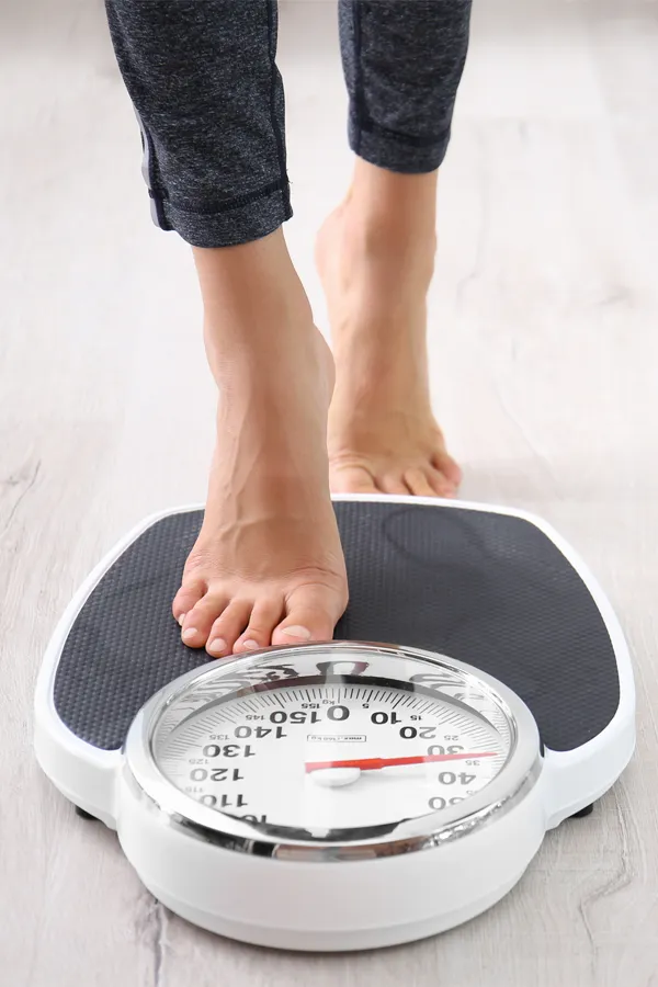 Close up of feet stepping onto a scale. Receive expert functional medicine for obesity treatment by Tanya Zboril, NP of TBT Medical in Edmonton.